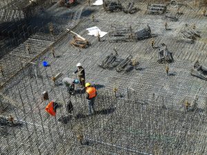 Construction workers amidst steel rebar, highlighting the importance of safety training from an online white card course.