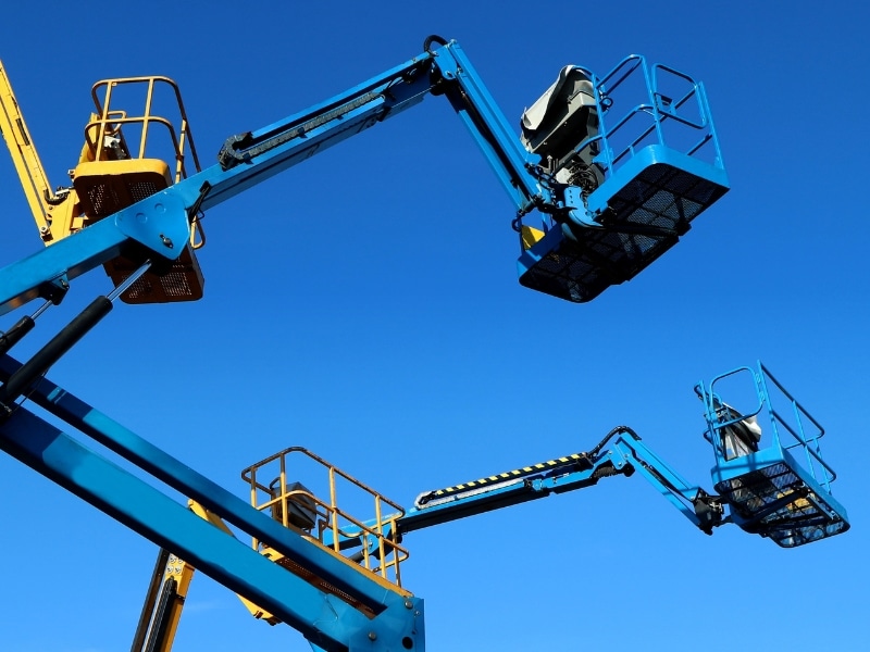 Two elevated work platforms (EWPs) against a blue sky, highlighting the importance of proper ewp training accreditation.
