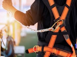 Construction worker in Sydney, Australia, wearing a safety harness and lanyard, emphasizing the importance of site safety and implicitly asking **how long to get a white card**, a requirement for working in the industry.