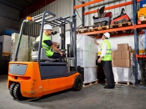 Forklift skills in action as an operator and supervisor manage warehouse storage